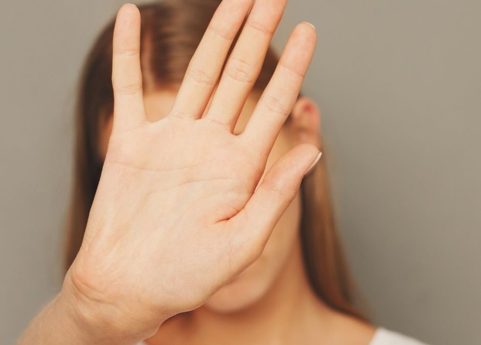Eine Frau hält ihre Hand vor ihr Gesicht, sie will etwas nicht akzeptieren