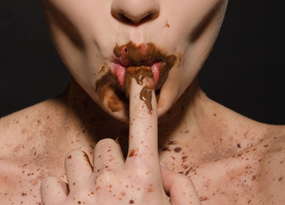 eine Frau die Schokolade isst - ein Sinnbild für Stressessen